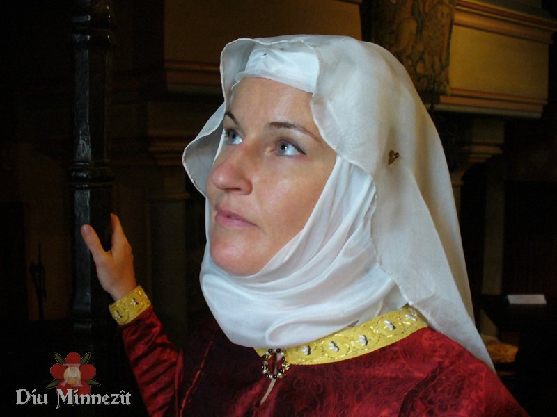 Nicole Perschau in prchtiger hochmittelalterlicher Kleidung mit Zierstickereien am Saum und Edelsteinbesetzter Fibel