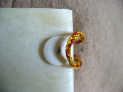 Detail des Verschlusses mit Beinknpfen und in Fingerschlaufentechnik gewebten Seidenbndern