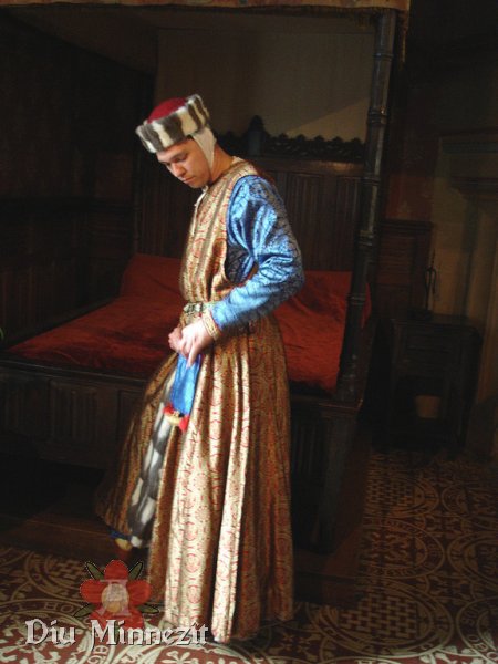 Hochmittelalterlicher Adliger mit Cotta und Surcot aus Damast und Hut mit Fehpelzverbrämung