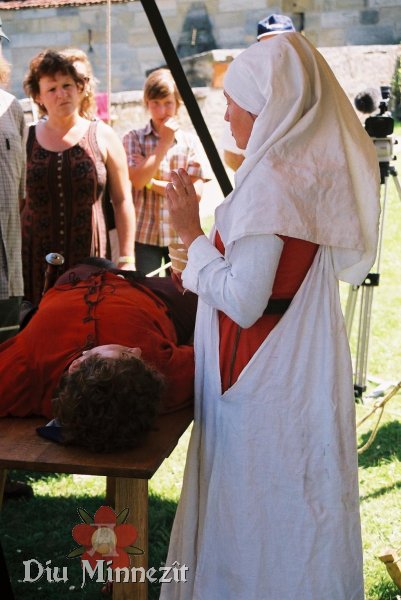 Spätmittelalterliche Ärztin vor der Behandlung eines Patienten