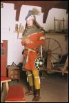 Ritter um 1350 bis 1360 in seidengefütterter Cotehardie, mit gegürtetem Schwert und Buckler