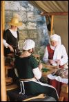 Damen in spätmittelalterlicher Tracht bei der Arbeit in der Küche des Lagers